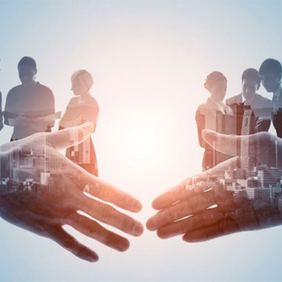 Dois parceiros de negócios apertando as mãos em um escritório moderno com janelas grandes mostrando a cidade, mesa de conferência com laptops e xícaras de café.